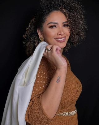 Viviane Araujo sorrindo, com jaleco no ombro.